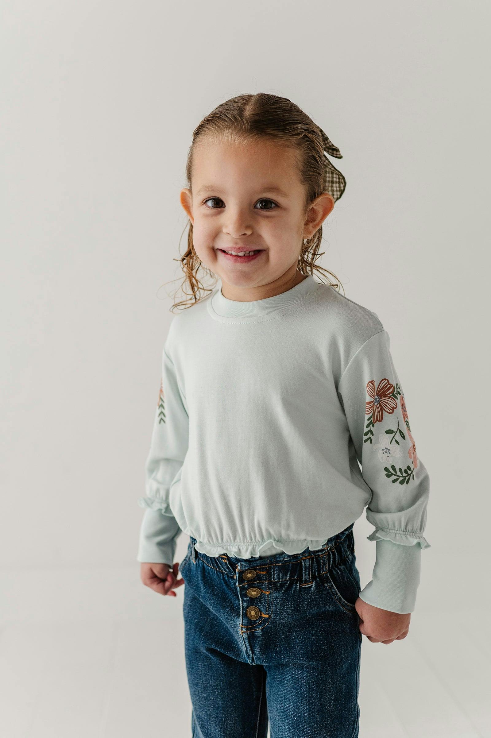 Girls Ruffle Hem Sweatshirt in Floral Sleeves in Misty Blue